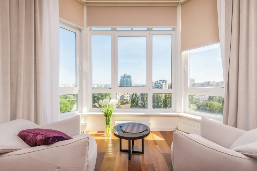 A sliding window installation in Lawrence showcases white frames, creating a bright seating area with city views and modern furniture.